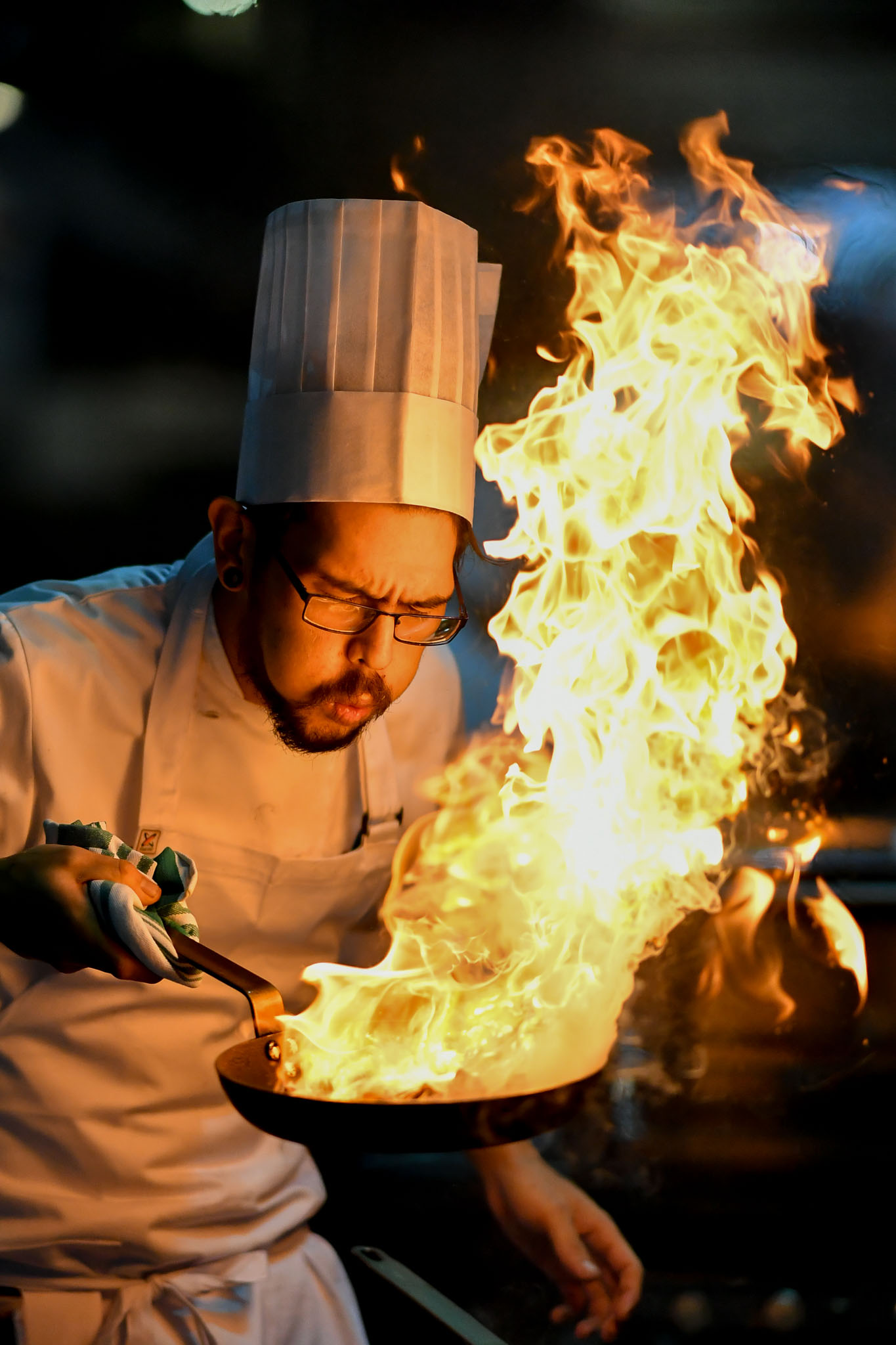 Melbourne, 30 May 2017 - Tyson Kromhout of the Salsa Bar & Grill in Port Douglas reacts to flames from his fry pan at the Australian selection trials of the Bocuse d'Or culinary competition held during the Food Service Australia show at the Royal Exhibition Building in Melbourne, Australia. Photo Sydney Low